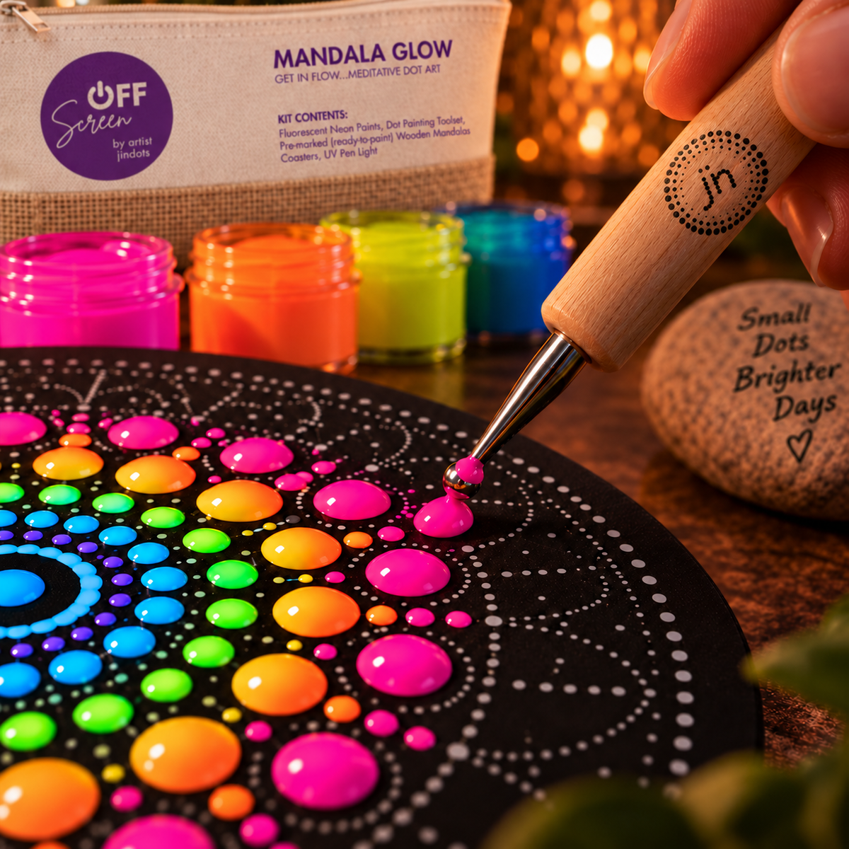 Close-up of a dotting tool placing fluorescent paint on a pre-marked Mandala Glow board