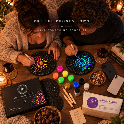 Overhead view of a couple painting Mandala Glow together with phones set aside